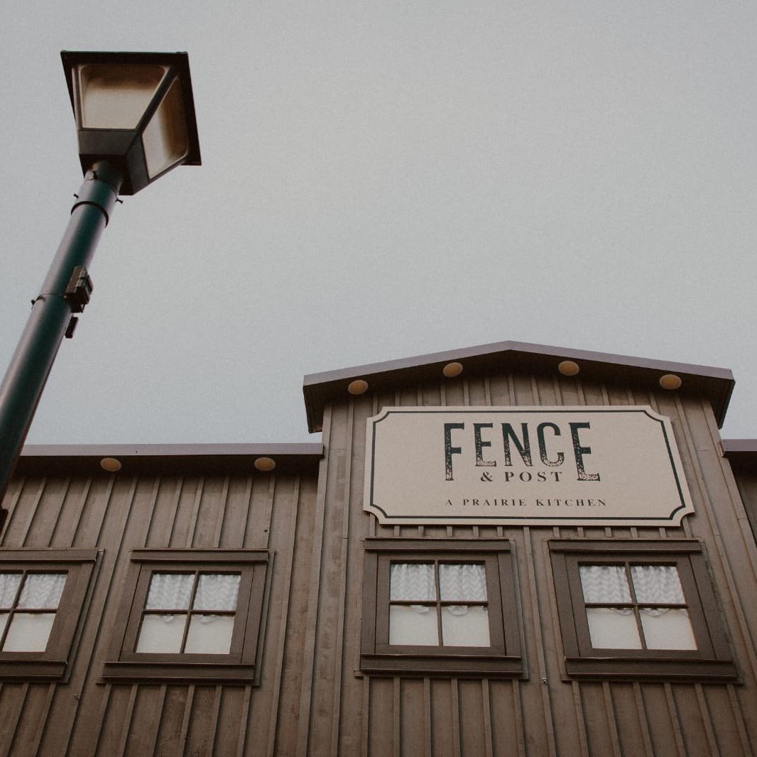 The Fence & Post signboard on the restaurant's board-and-batten front